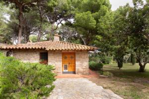 a small stone house with a door in a forest at Ca la Irene I in Begur