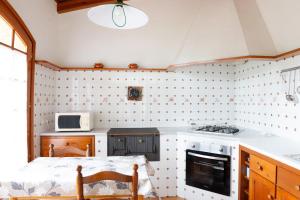 a kitchen with a stove and a microwave at Ca la Irene I in Begur