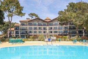 a large hotel with a large pool in front of it at Appartement Olivia in Moliets-et-Maa