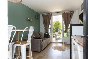 a living room with a couch and a table and chairs at Appartement Olivia in Moliets-et-Maa