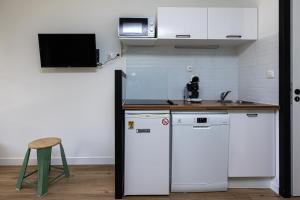 a kitchen with a white refrigerator and a sink at Appartement Olivia in Moliets-et-Maa