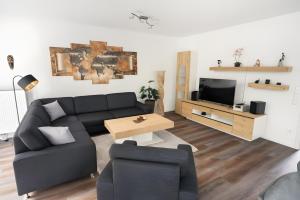 a living room with a couch and a tv at Gästehaus Lean in Potsdam