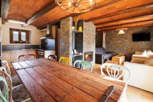 a kitchen and living room with a wooden table and chairs at Masia d'en cot in Puigcerdà