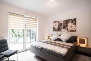 a bedroom with a bed and a chair and a window at Gästehaus Lean in Potsdam