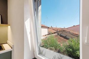 an open window with a view of a building at Torri e tramonti in Albenga