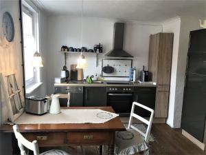 a kitchen with a table and a stove top oven at Ferienwohnung Bei Der Kirch in Münsingen