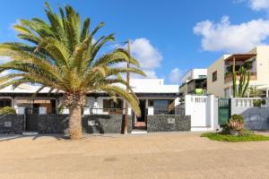 a palm tree in front of a house at Salitre in Playa Honda