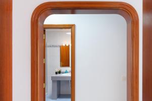 a mirror with a wooden frame in a bathroom at Salitre in Playa Honda