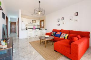 a living room with a red couch and a table at Salitre in Playa Honda +19 photos