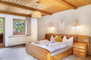 a bedroom with a large bed and a window at A Nett’s Nest - Haus in Hainzenberg