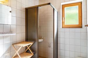 a shower with a glass door in a bathroom at A Nett’s Nest - Haus in Hainzenberg +37 photos