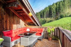 a patio with chairs and a table on a balcony at A Nett’s Nest - Haus in Hainzenberg