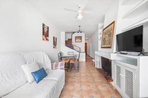 a living room with a white couch and a fireplace at Casa Varadero in Santa Pola