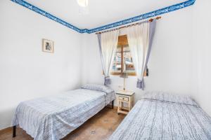 a bedroom with two beds and a window at Casa Varadero in Santa Pola +13 photos