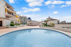 a large swimming pool in a courtyard of a building at Casa Varadero in Santa Pola