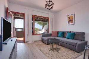 a living room with a couch and a tv at Casa Ann in Arrecife