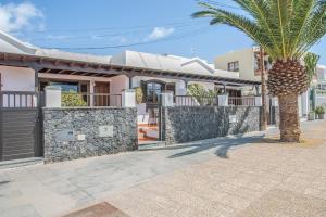 a palm tree in front of a house at Casa Ann in Arrecife