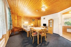 a dining room with a wooden ceiling and a table at Bungalow 13 - Finnhütte in Niesky