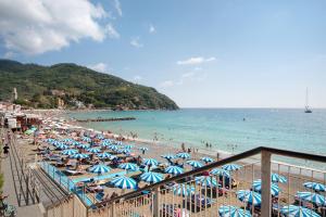 a beach with many umbrellas and people in the water at Beach Paradise - Cicerone in Levanto