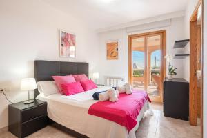 a bedroom with a large bed with pink pillows at Vista Mar y Tierra in Marratxí  +19 photos