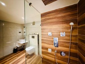 a bathroom with a toilet and a glass shower at Hotel Kama, Patna in Patna
