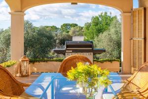 a patio with a glass table and a grill at Vista Mar y Tierra in Marratxí 