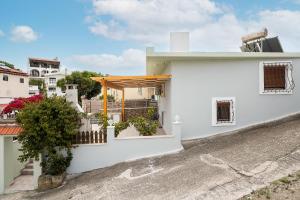 a white house with a porch and a fence at Villa Nikolaos in Rhodes Town