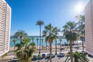 a view of a beach with palm trees and the ocean at Apartamento las Palmeras 3 in Benicarló