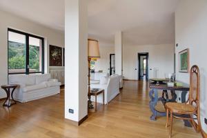 a living room with white furniture and a table at Appartamento Il Parco Cernobbio in Cernobbio