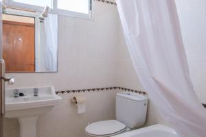 a bathroom with a toilet and a sink and a mirror at Apartamento las Palmeras 3 in Benicarló +13 photos