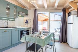 a kitchen with blue cabinets and a table with chairs at Le Petit Appartement de Saint-Denis in Saint-Denis-dʼOléron +37 photos