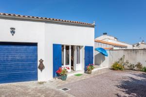 a white house with blue doors and a fence at Le Petit Appartement de Saint-Denis in Saint-Denis-dʼOléron