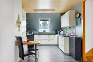 a kitchen with white cabinets and a table at Ferienwohnung am Rosenberg in Stockach