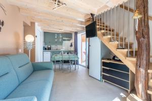 a living room with a blue couch and a staircase at Le Petit Appartement de Saint-Denis in Saint-Denis-dʼOléron