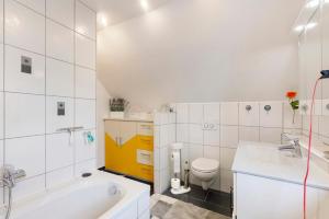 a bathroom with a tub and a toilet and a sink at Ferienwohnung am Rosenberg in Stockach +21 photos