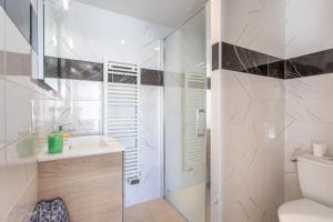 a bathroom with a shower and a sink and a toilet at Le Petit Appartement de Saint-Denis in Saint-Denis-dʼOléron
