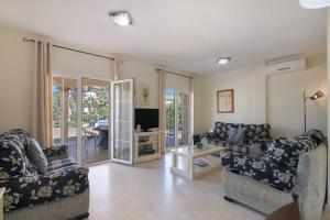 a living room with two couches and a television at Luxury villa in Islantilla