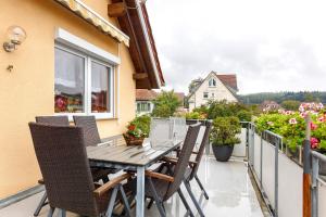 a table and chairs on the balcony of a house at Ferienwohnung am Rosenberg in Stockach