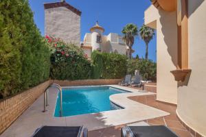 a swimming pool in the backyard of a house at Luxury villa in Islantilla