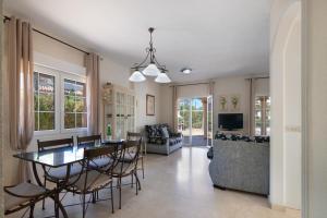 a dining room and living room with a table and chairs at Luxury villa in Islantilla