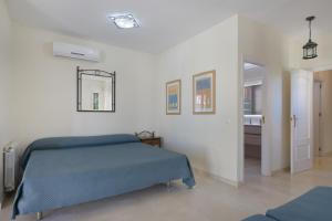 a bedroom with a blue bed and a bathroom at Luxury villa in Islantilla +26 photos