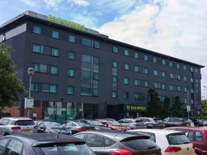 a large building with cars parked in a parking lot at B&B HOTEL Derby in Derby +16 photos