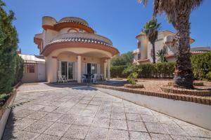 a house with a palm tree in front of it at Luxury villa in Islantilla
