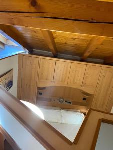 a bed in a room with wooden cabinets at Emma Home in Mezzolombardo +23 photos