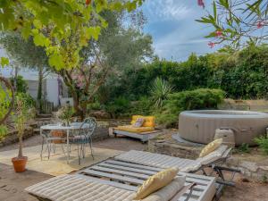 a patio with a hot tub and a table and chairs at Villa Esterel, Pour 14 Pers in La Faute-sur-Mer