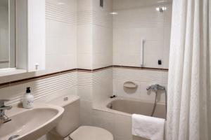 a bathroom with a tub and a sink and a toilet at Tramuntana apart in Calafell +18 photos