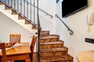 a living room with a staircase and a table and a tv at Emma Home in Mezzolombardo