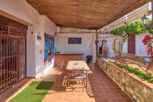 a room with a table and chairs on a patio at Cortijo Las Gregorias in Lucena