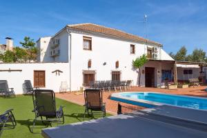 a white house with a swimming pool in the yard at Cortijo Las Gregorias in Lucena