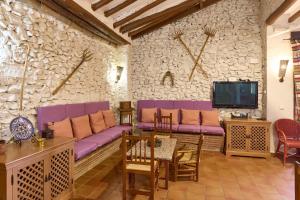 a living room with a purple couch and a tv at Cortijo Las Gregorias in Lucena